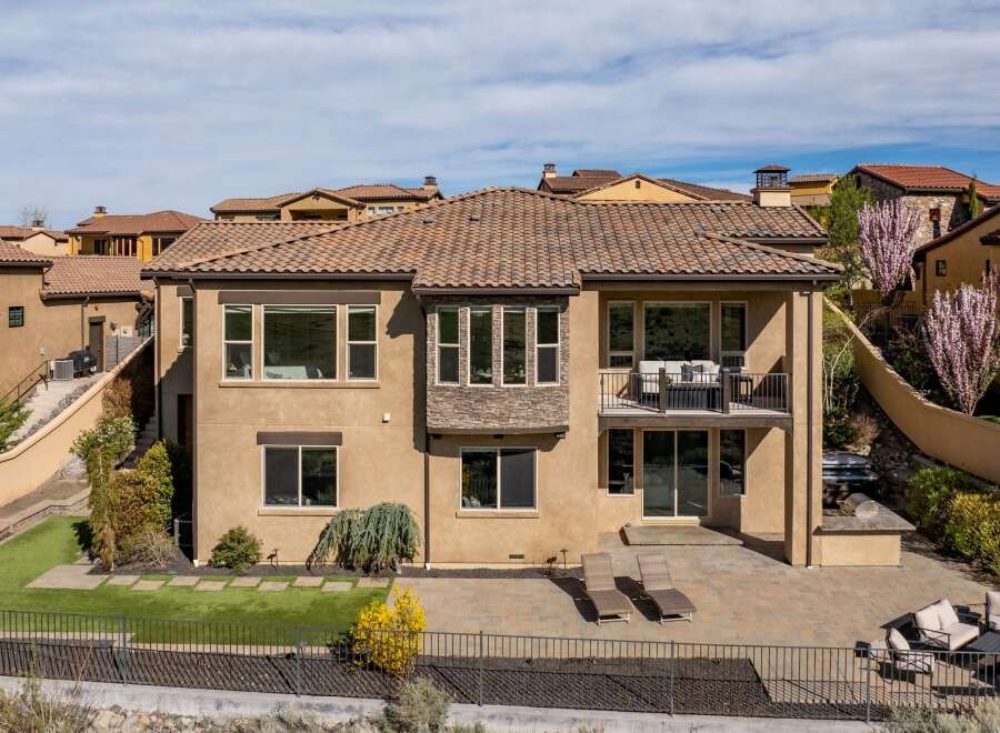 This stunning property boasts a luxurious design with a beautiful tile roof and a spacious patio, perfect for outdoor entertaining.