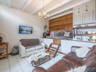 This cozy living space features a unique design with a raised platform and wooden accents, creating a warm and inviting atmosphere.