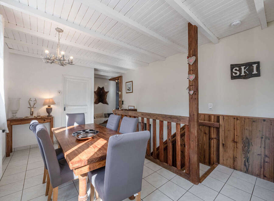 This charming property features a cozy dining area with a rustic wooden table and comfortable seating.