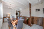 This charming property features a cozy dining area with a rustic wooden table and comfortable seating.