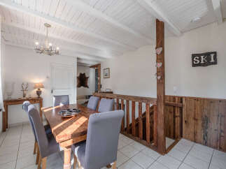 This charming property features a cozy dining area with a rustic wooden table and comfortable seating.
