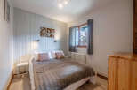 This cozy bedroom offers a serene retreat with its warm wooden accents and inviting ambiance.