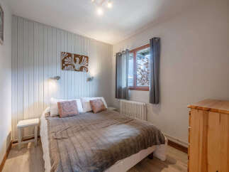 This cozy bedroom offers a serene retreat with its warm wooden accents and inviting ambiance.