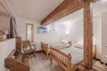 This cozy bedroom features two twin beds with wooden frames, perfect for a comfortable stay.
