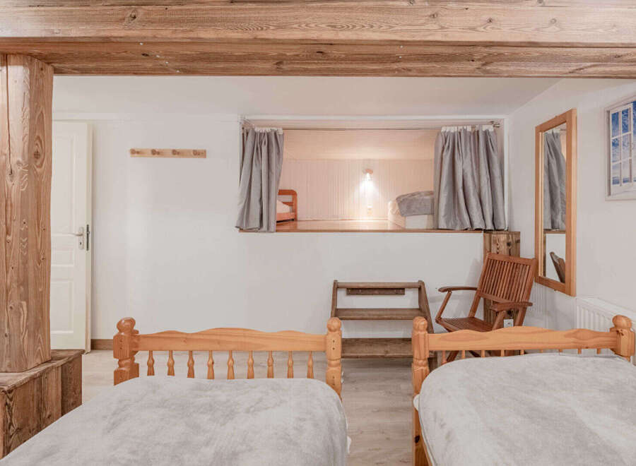 This charming bedroom features a unique design with exposed wooden beams and a cozy sleeping nook.