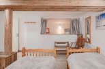 This charming bedroom features a unique design with exposed wooden beams and a cozy sleeping nook.