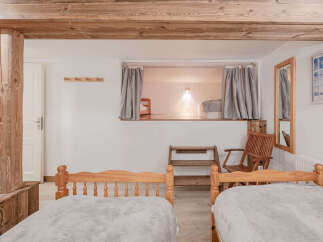 This charming bedroom features a unique design with exposed wooden beams and a cozy sleeping nook.
