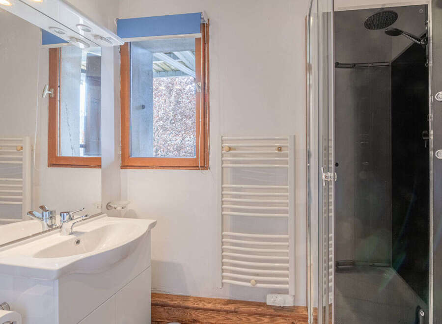 This bathroom features a modern design with a sleek white vanity and a spacious shower.