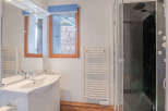 This bathroom features a modern design with a sleek white vanity and a spacious shower.