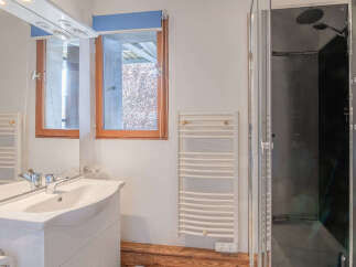 This bathroom features a modern design with a sleek white vanity and a spacious shower.