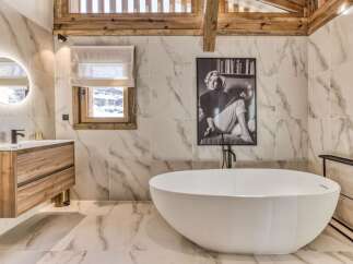 This luxurious bathroom features a stunning marble tile design, a modern soaking tub, and a stylish vanity.