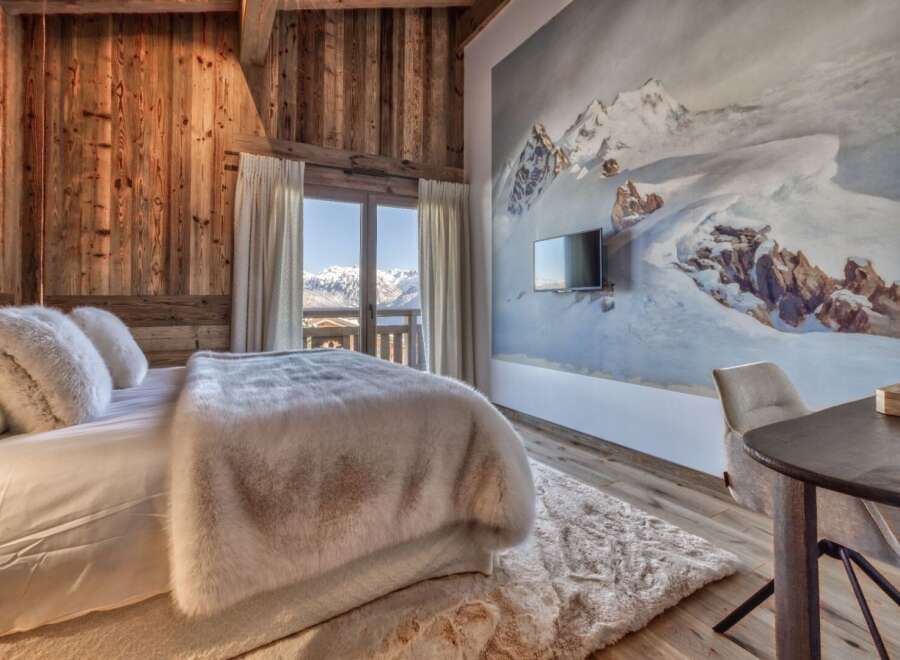 Experience luxury living in this stunning bedroom, featuring a cozy bed adorned with plush pillows and a faux fur throw.