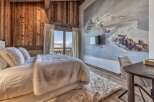 Experience luxury living in this stunning bedroom, featuring a cozy bed adorned with plush pillows and a faux fur throw.