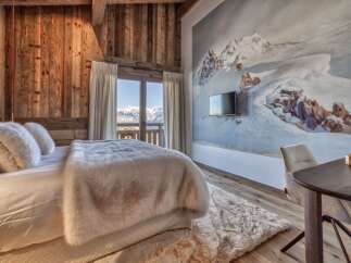 Experience luxury living in this stunning bedroom, featuring a cozy bed adorned with plush pillows and a faux fur throw.