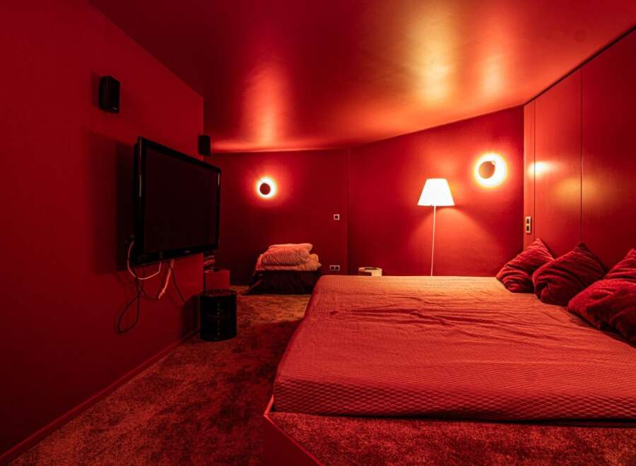 Step into a world of luxury and comfort with this stunning red-themed bedroom.