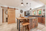 This stunning kitchen boasts a rustic charm with its wooden cabinetry and island, creating a warm and inviting atmosphere.