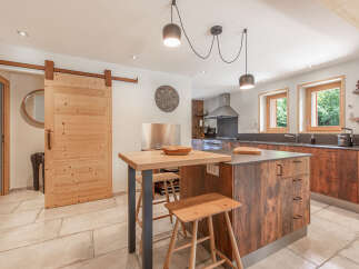 This stunning kitchen boasts a rustic charm with its wooden cabinetry and island, creating a warm and inviting atmosphere.