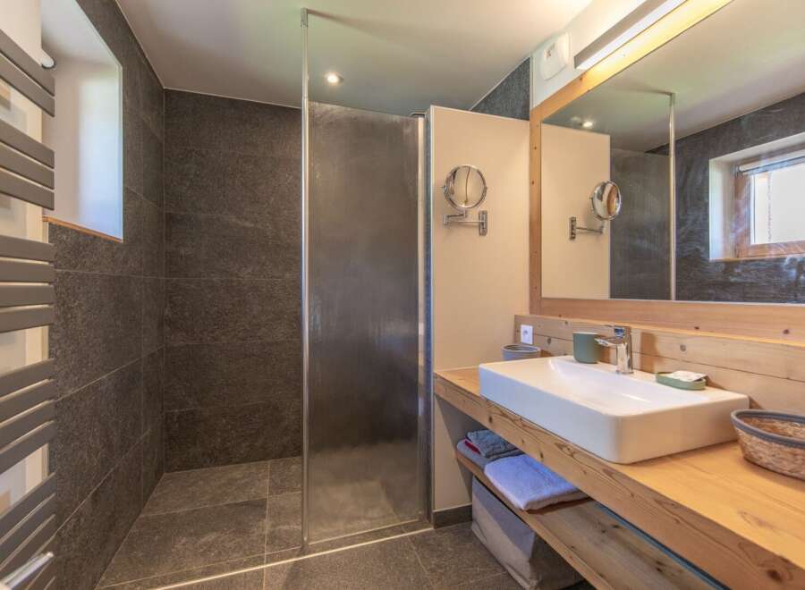 This modern bathroom features a sleek design with a walk-in shower and a stylish vanity.