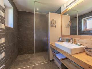 This modern bathroom features a sleek design with a walk-in shower and a stylish vanity.