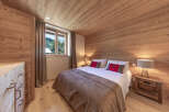 Experience the warmth of this inviting bedroom, featuring stunning wood paneling on the walls and ceiling.