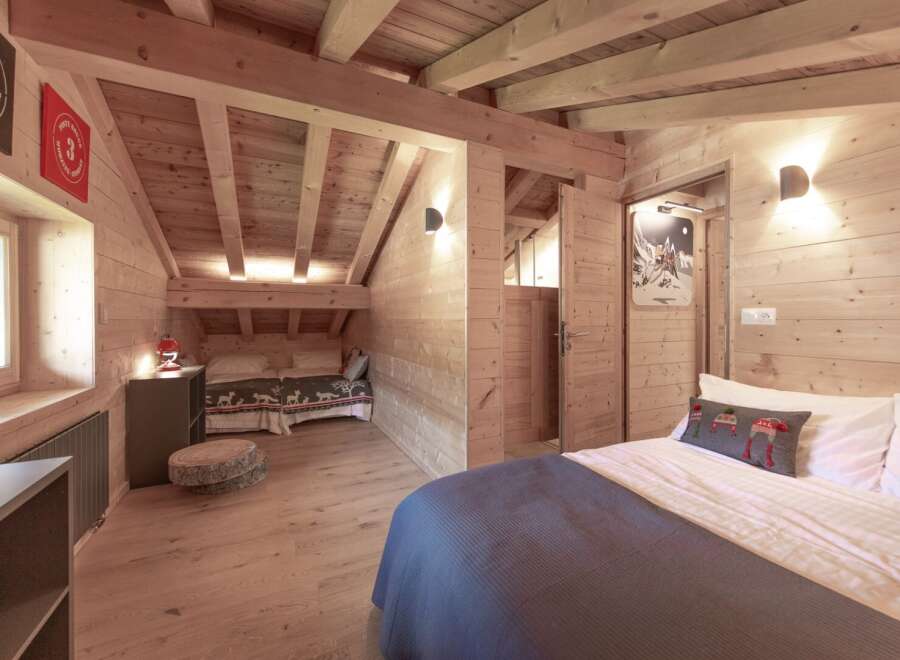 Step into this charming chalet-style bedroom, featuring warm wooden accents and a cozy atmosphere.
