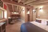 Step into this charming chalet-style bedroom, featuring warm wooden accents and a cozy atmosphere.