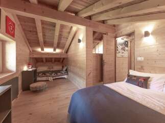 Step into this charming chalet-style bedroom, featuring warm wooden accents and a cozy atmosphere.