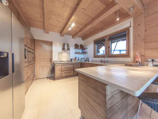 This stunning kitchen boasts a rustic charm with its wooden beams and cabinetry, creating a warm and inviting atmosphere.