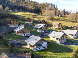 Discover a charming collection of chalets nestled in a picturesque mountain setting.