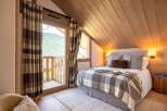Experience the charm of this cozy bedroom, featuring a stunning mountain view from the balcony.
