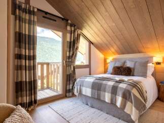Experience the charm of this cozy bedroom, featuring a stunning mountain view from the balcony.
