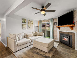 This cozy living room features a comfortable sectional sofa and a stylish ottoman, perfect for relaxing.