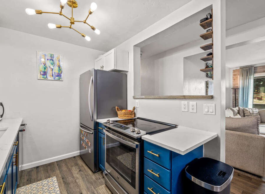 This stunning kitchen boasts modern appliances and stylish blue cabinetry.