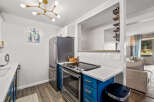 This stunning kitchen boasts modern appliances and stylish blue cabinetry.