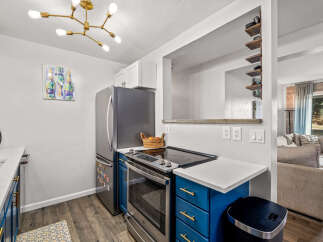 This stunning kitchen boasts modern appliances and stylish blue cabinetry.