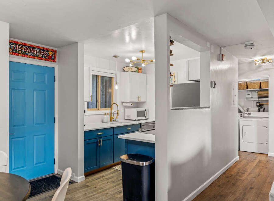 This charming property features a beautifully designed kitchen with modern blue cabinetry and sleek countertops.