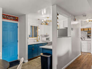 This charming property features a beautifully designed kitchen with modern blue cabinetry and sleek countertops.