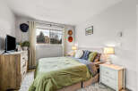 This cozy bedroom offers a serene retreat with its inviting ambiance and stylish decor.