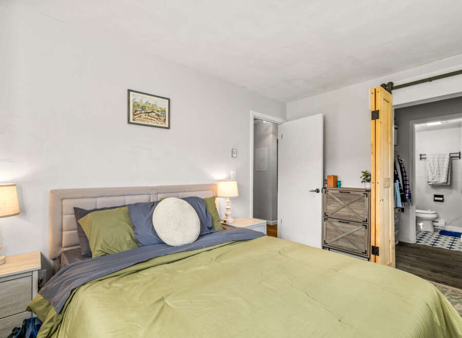 This inviting bedroom offers a serene retreat with its neutral color palette and cozy ambiance.