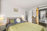 This inviting bedroom offers a serene retreat with its neutral color palette and cozy ambiance.