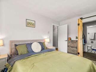 This inviting bedroom offers a serene retreat with its neutral color palette and cozy ambiance.