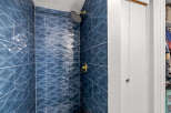 Step into luxury with this stunning bathroom! Featuring exquisite blue tile work and a modern shower head, this space is designed for ultimate relaxation.