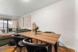 This stunning property features a modern dining area with a beautiful wooden table and stylish black chairs.