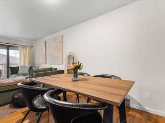 This stunning property features a modern dining area with a beautiful wooden table and stylish black chairs.