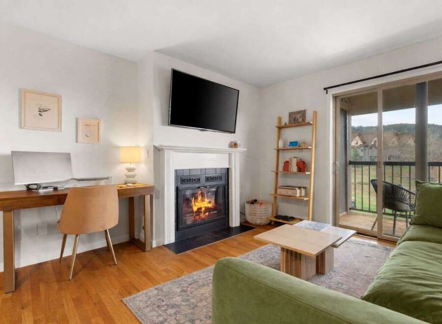 This stunning property features a cozy living room with a fireplace and a modern TV, perfect for relaxing evenings.