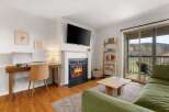 This stunning property features a cozy living room with a fireplace and a modern TV, perfect for relaxing evenings.