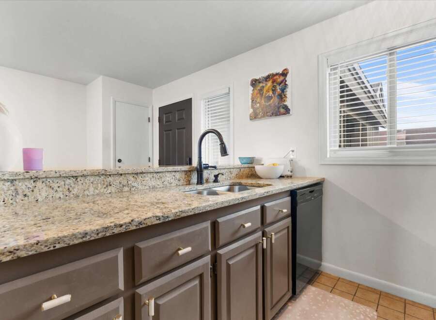 This kitchen boasts a stylish design with granite countertops and modern cabinetry.