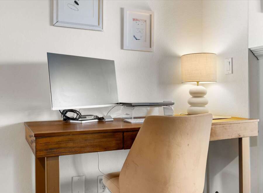 Discover the perfect workspace in this stylish home office! Featuring a sleek wooden desk, a comfortable chair, and a modern computer setup, this space is designed for productivity and comfort.