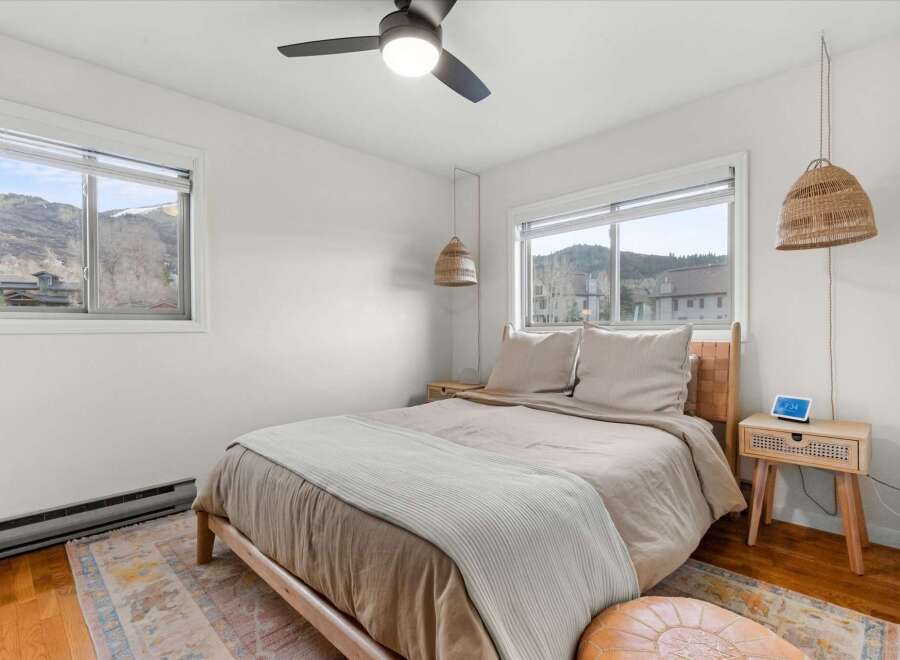 This cozy bedroom offers a serene retreat with its neutral color palette and natural light.