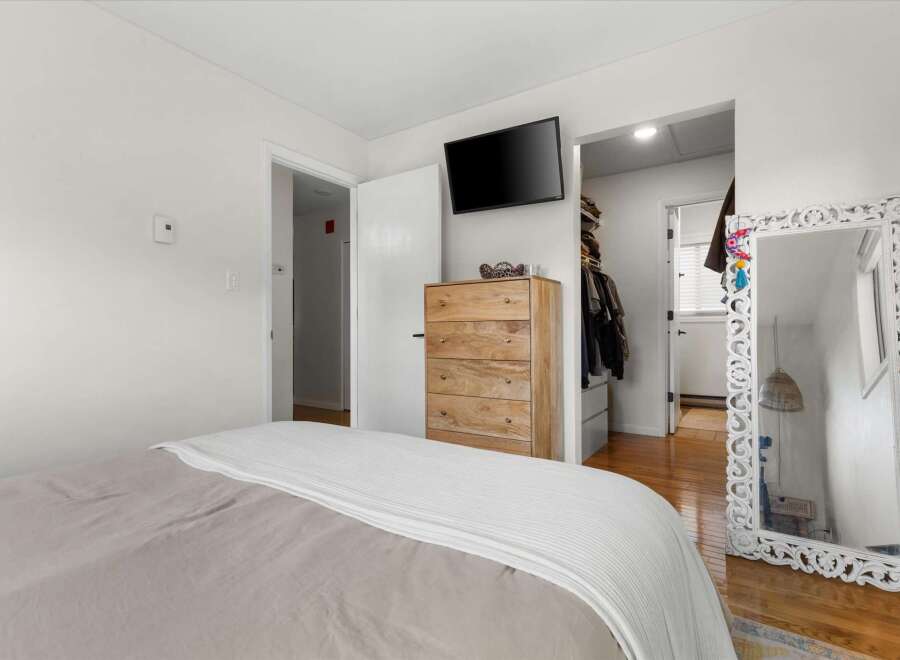 This inviting bedroom features a stylish wooden dresser, perfect for storage and adding a touch of warmth.
